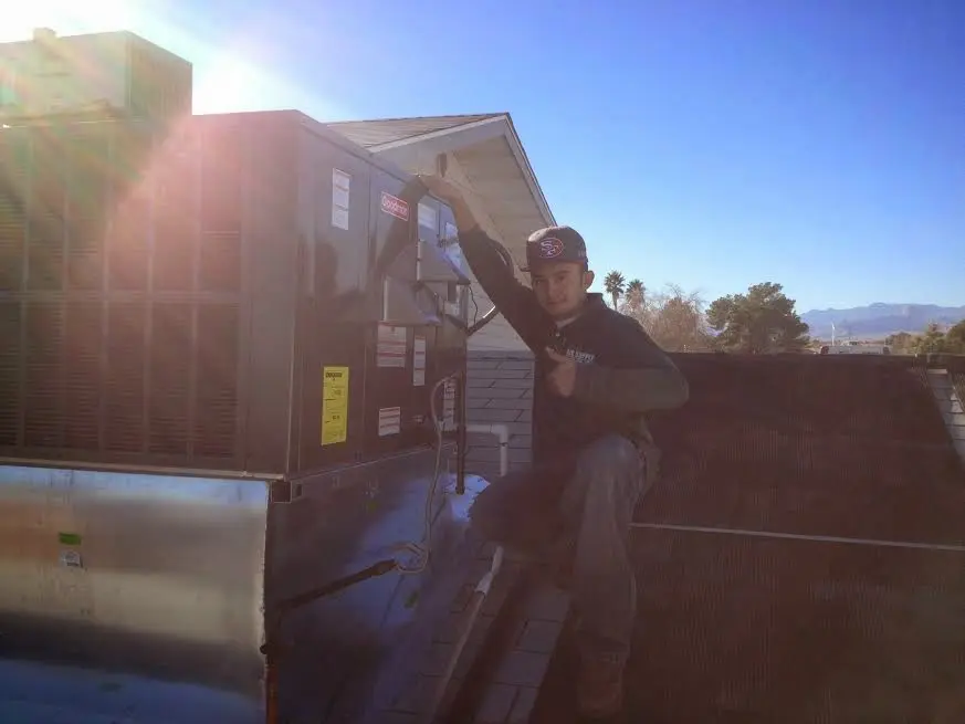 HVAC technician performing AC Tune-Up on a rooftop unit in Alvarado